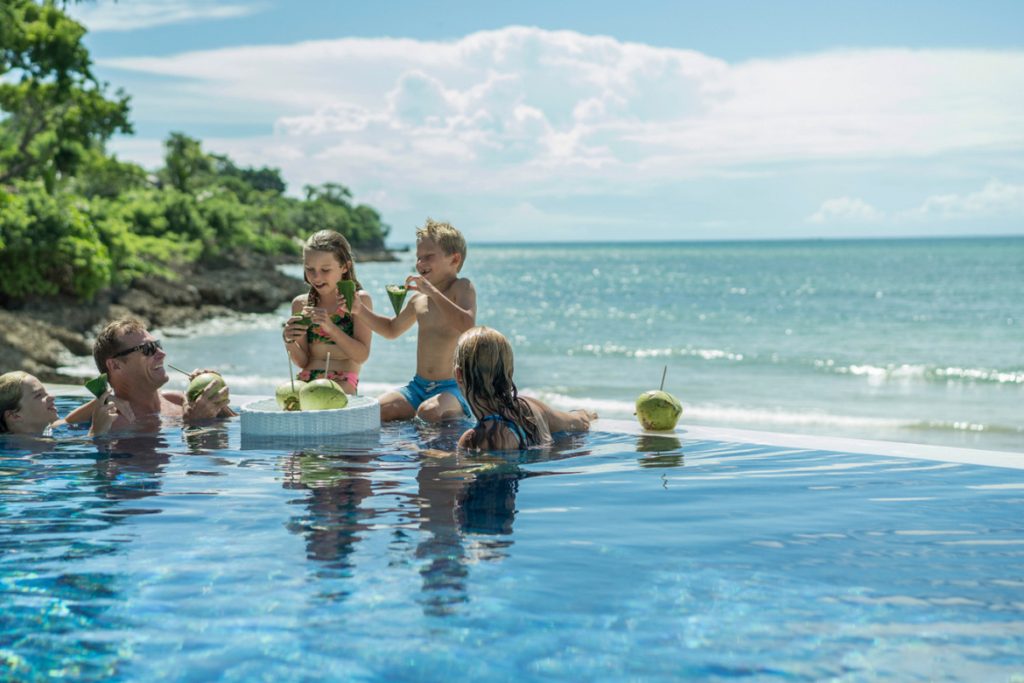 Family in infinite pool at Four Seasons Resort Bali at Jimbaran Bay