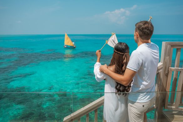 Avani+ Maldives cocktail boat couple waving